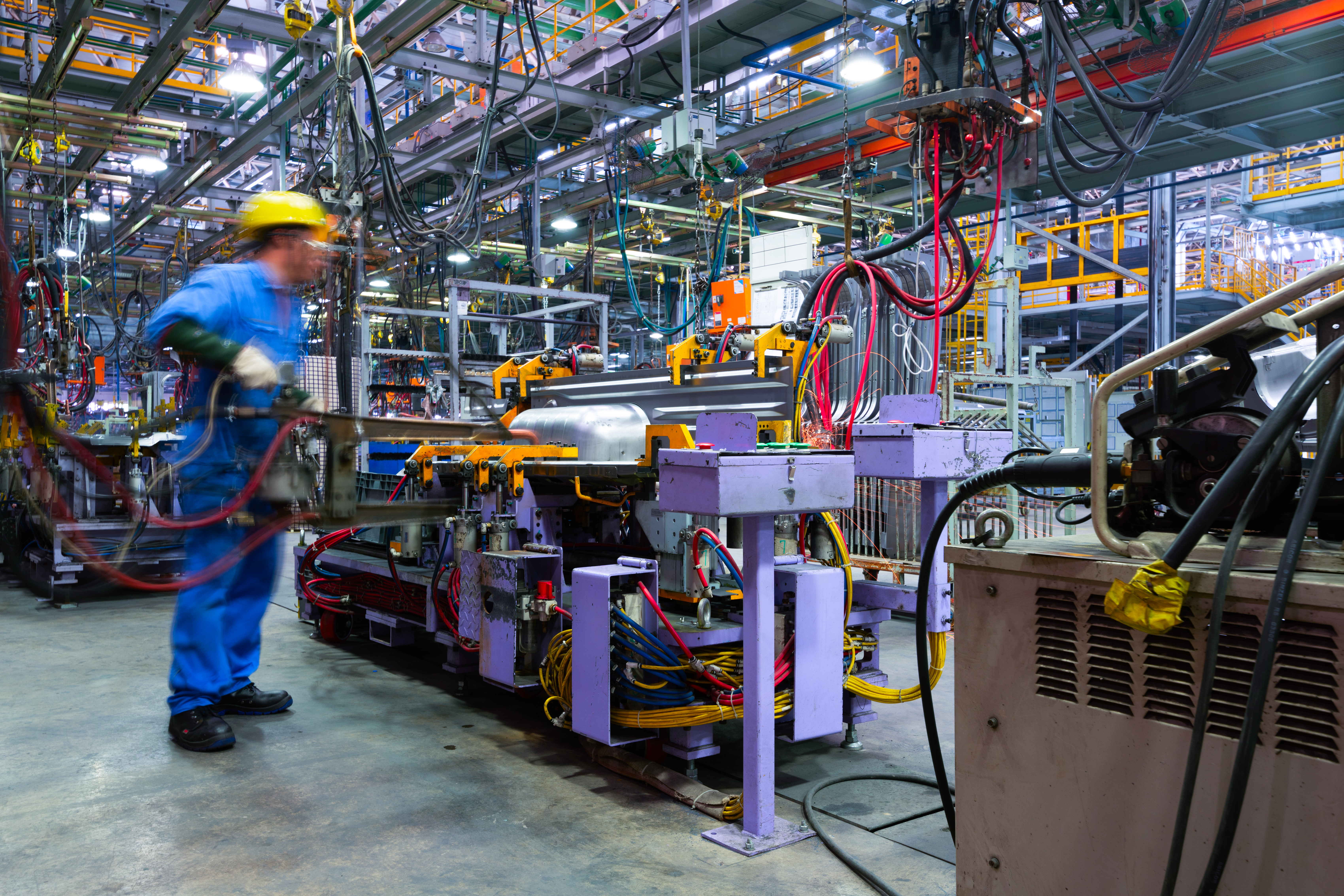 Automated assembly line with robotics, compressed gasses, and a welding station in a manufacturing facility